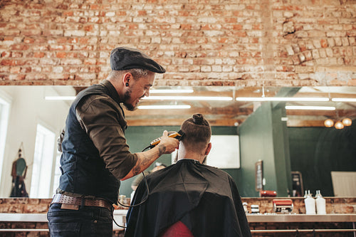 Hairdresser cutting hair of client
