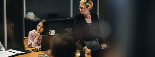 Businesspeople in meeting room at night