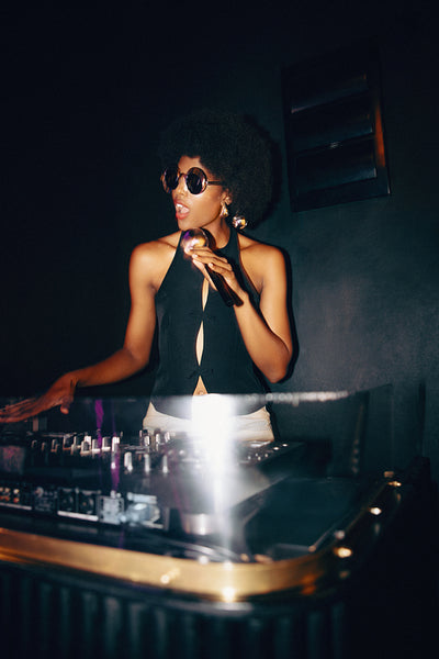 DJ performing at a nightclub spinning music with a stylish appearance