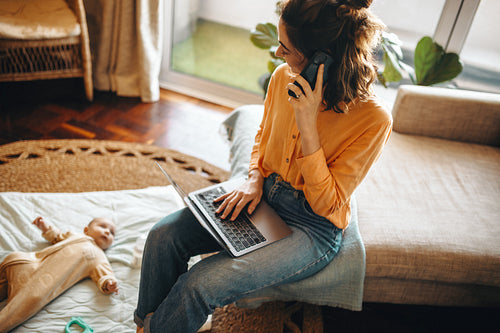 Mother works from home with baby nearby