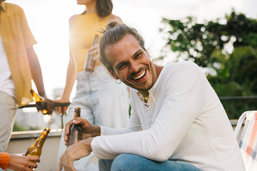 Happy man enjoying drinks outside with friends on the weekend