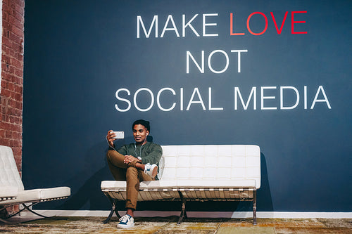 Creative businessman speaking on a video call in an office lobby