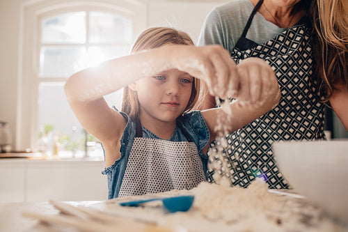 Beautiful little girl learns to cook a meal in the kitchen