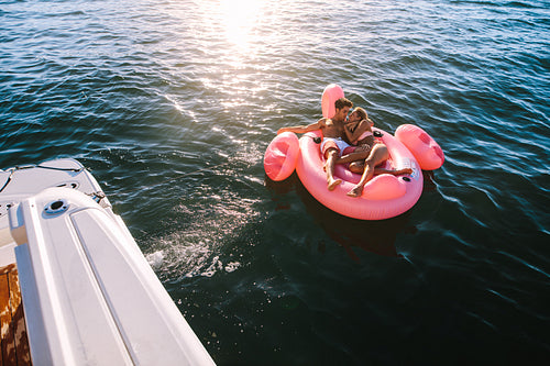 Romantic couple relaxing on inflatable top in sea