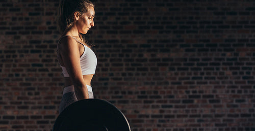 Strong woman lifting heavy weights at gym