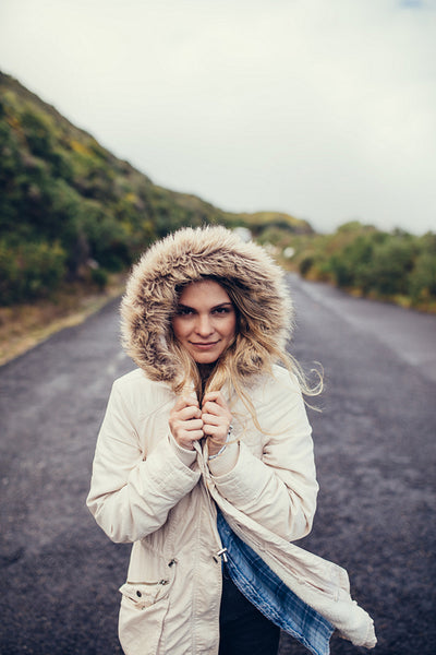 Woman in warm clothing on open road
