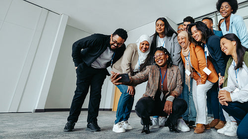Diverse group of colleagues taking a selfie during a team bonding session at the office