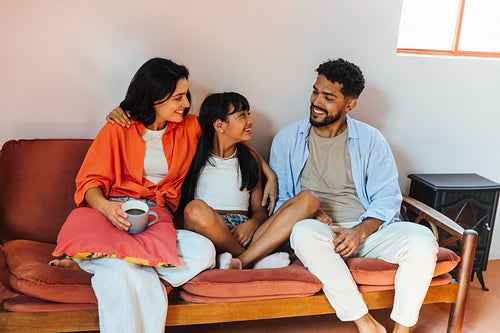 Happy Latin American family sitting together on a comfortable couch at home