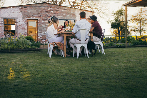 Group of people enjoying summer meal at restaurant