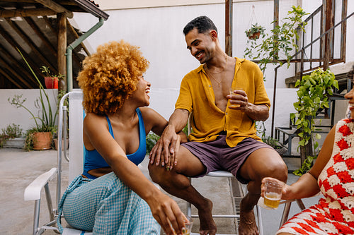 Friends enjoying drinks together outdoors on a sunny day