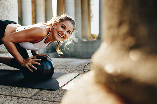 Smiling fitness woman doing workout using a medicine ball