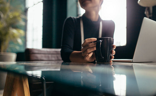 Female hand holding cup of coffee