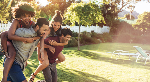 Couples piggyback ride race in backyard