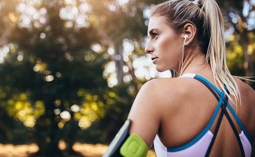 Woman runner wearing earphones during workout