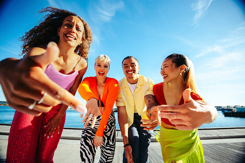 Friends singing and rapping towards the camera by the waterfront in summer