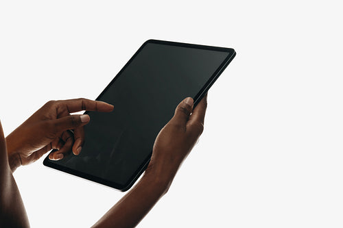 Person using a tablet with a blank screen in their hands