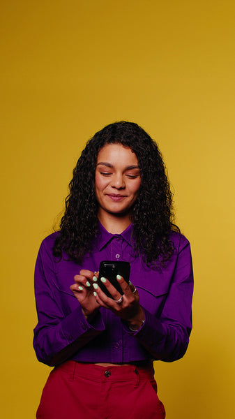 Young woman laughs while scrolling her phone