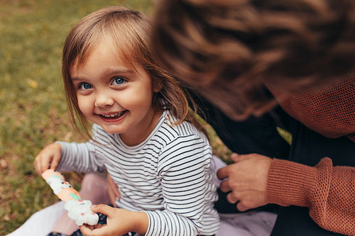 Little girl with her father outdoors holding a candy