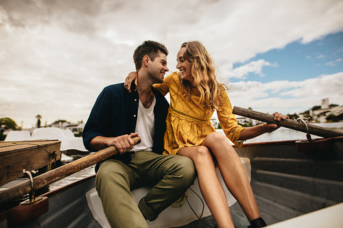 Man and woman sitting in a boat looking at each other