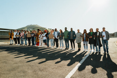 Diverse group of people holding hands outdoors during a peaceful demonstration