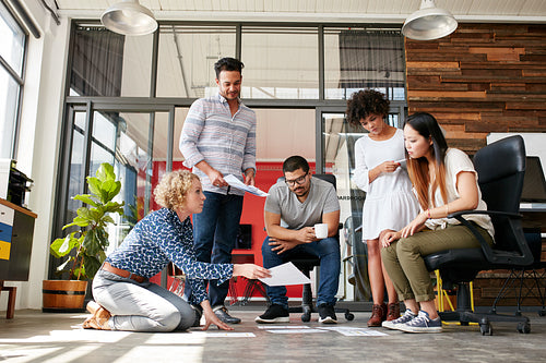 Designers planning layout on floor of office