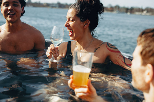 Hot tub spa relaxation with adults enjoying drinks in outdoor water together