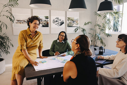 Team of women collaborating on planning and drawings in a modern office