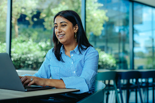Confident female lawyer working on a laptop in a modern office