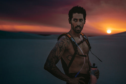 Athlete having a break in desert at sunset