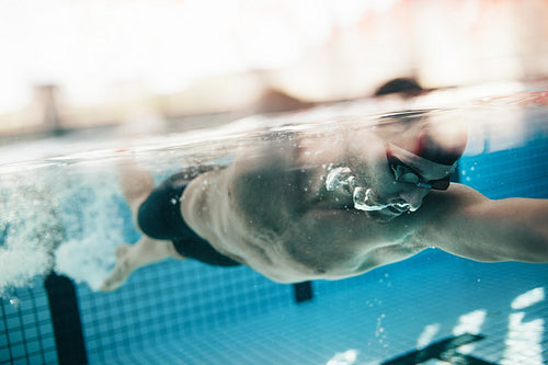Male athlete swimming in pool.