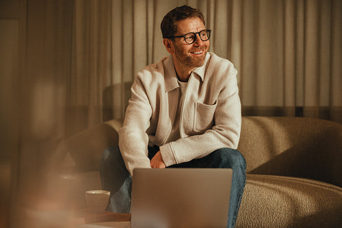 Business man sits with a laptop in a home office for remote work