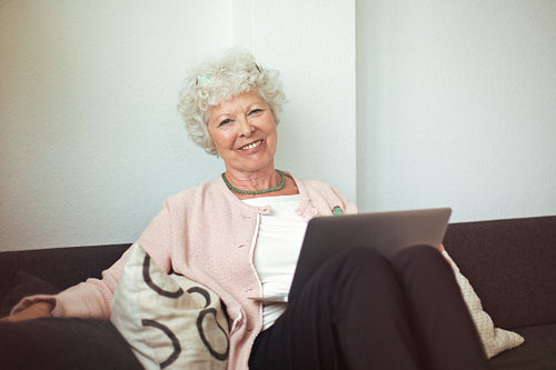 Happy Senior Lady at Home with Laptop