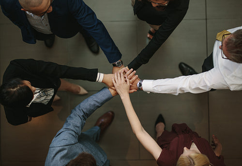 Business team putting hands together at the office