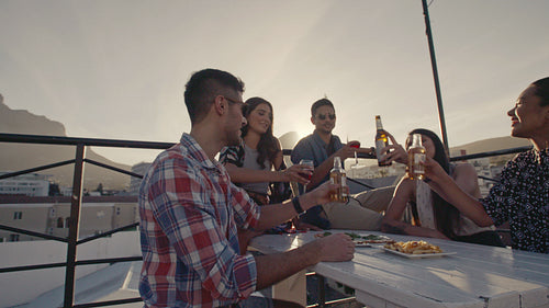 Friends toasting drinks at a rooftop party