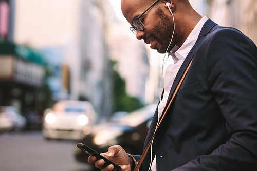 Businessman commuting with a smartphone on city street
