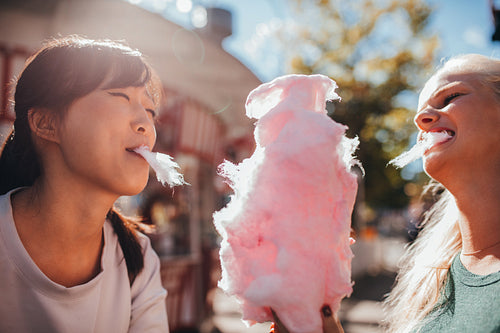 Two young women sharing cotton candyfloss