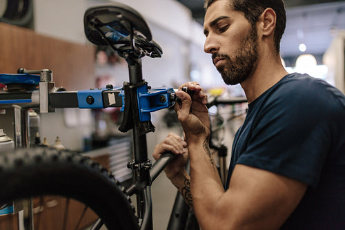 Mechanic repairing a bicycle in workshop