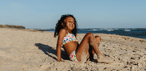 Happy girl enjoying a sunny day at the beach during a summer vacation
