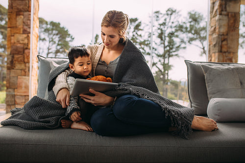 Mother and son with digital tablet in the living room