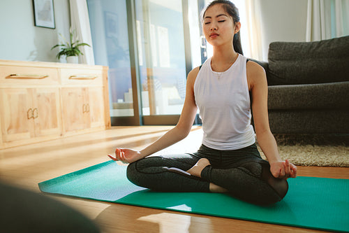 Beautiful woman doing yoga exercise indoors