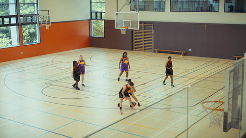 Young women playing basketball together