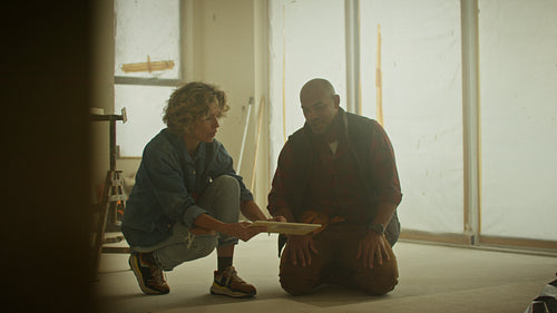 Couple planning home renovation examining tiles in new apartment