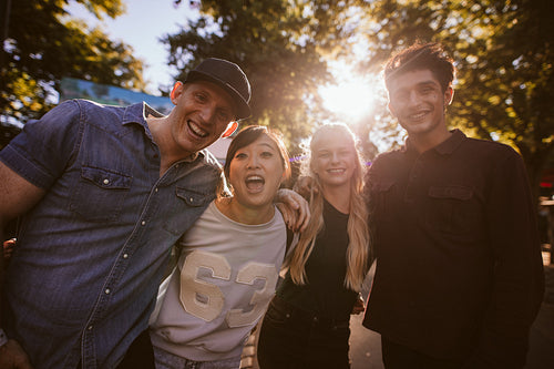 Excited young friends standing together at amusement park