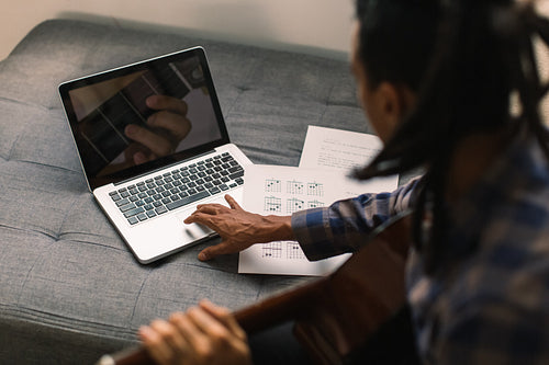 Guitarist having online music lessons during quarantine