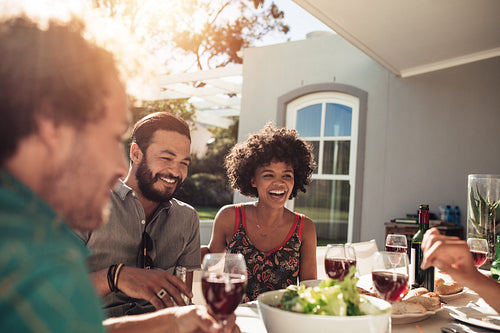 Friends having meal together outside their home