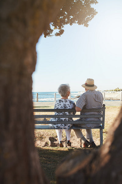 Senior couple sitting on bench near the sea