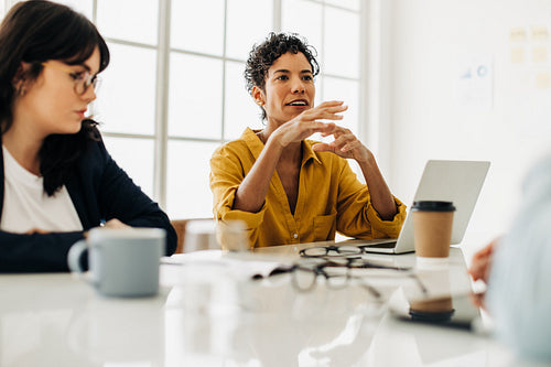 Woman having a discussion with her team in a boardroom