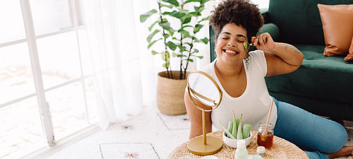 Healthy woman using jade roller on face skin