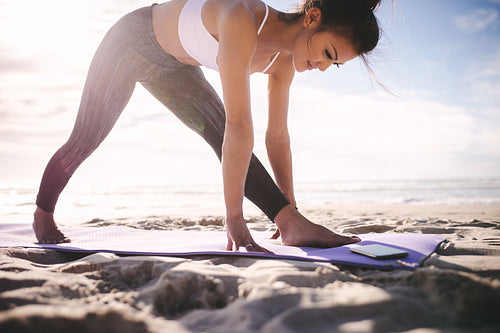 Sporty woman stretching on a beach