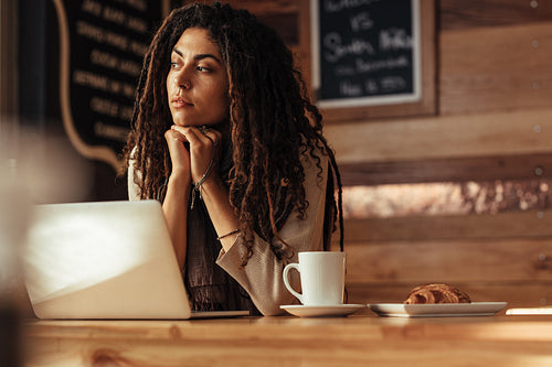 Freelancer woman sitting at a cafe with her laptop computer